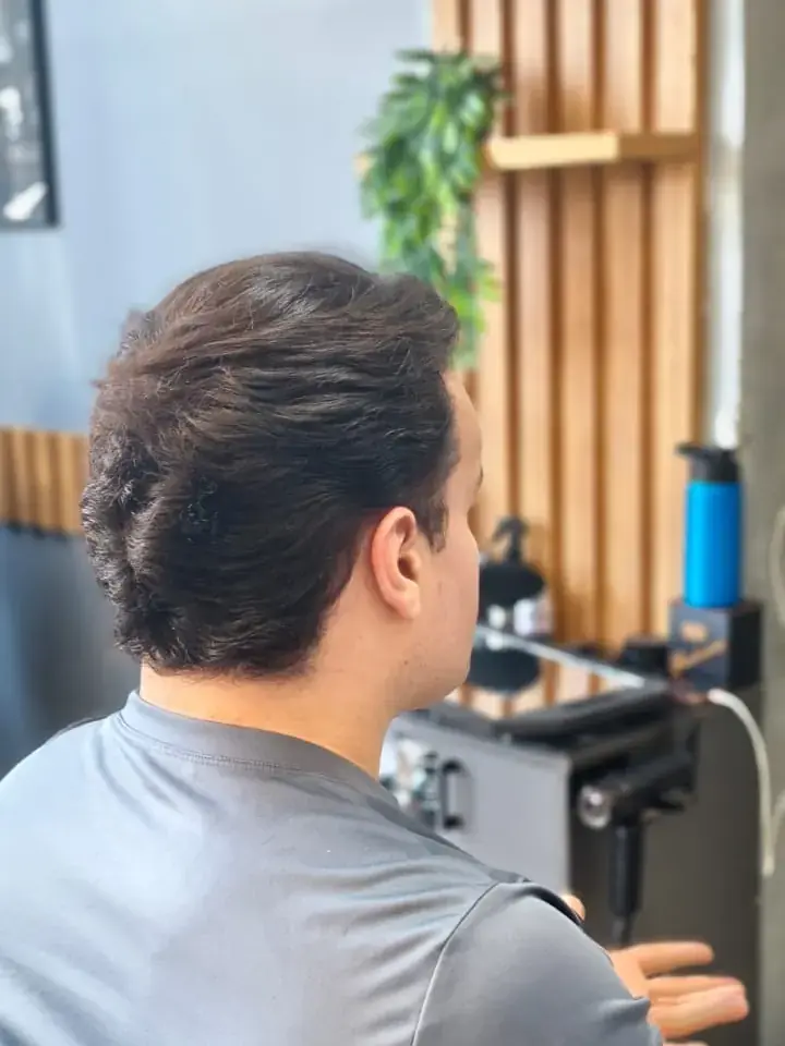 Acabamento e pezinho com o Thiego Faria Cliente de lado na cadeira, com o cabelo escuro cortado e a nuca alinhada