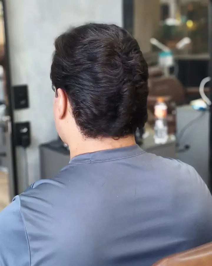 Selagem com o Thiego Faria Cliente de costas na cadeira marrom, com o cabelo escuro e a nuca alinhada depois da selagem
